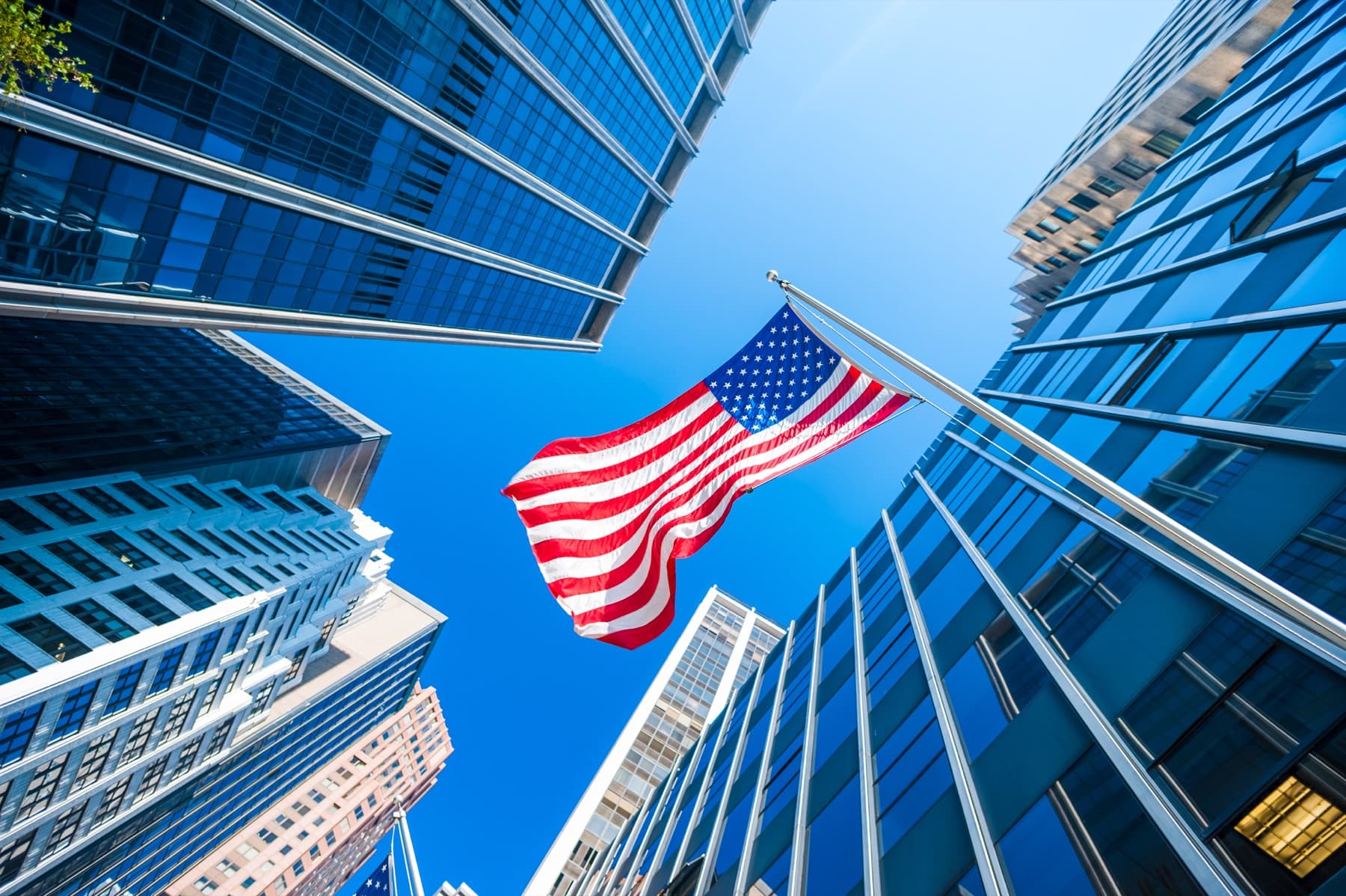 United States flag reflected between corporate office buildings